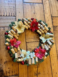 a wreath made out of wine corks with poinsettia and other decorations