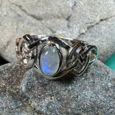 a silver ring with a blue stone in the center on top of a large rock