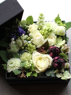 a black box filled with white and purple flowers