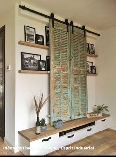 a living room with an old wooden door and some pictures on the wall above it