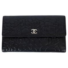 100% authentic Chanel wallet in black smooth leather embossed with Camelia's and CC logo's. Opens with a push-button to a metallic silver leather lined interior with 8 credit card slots, a zipped coin pocket and 4 compartments for bills or notes. Has been carried and shows faint wear on the lining. Overall in excellent condition. Measurements Width 20cm (7.8in) Height 12cm (4.7in) Depth 2cm (0.8in) Hardware Silver-Tone All our listings include only the listed item unless otherwise specified in the description above Kelly Wallet, Chanel Wallet, Large Wallet, Chanel Black, Small Accessories, Fashion Handbags, Embossed Leather, Emboss, Smooth Leather