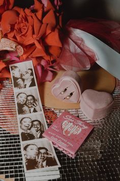 an arrangement of pink and orange flowers, pictures, and other items