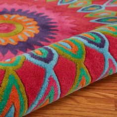 the colorful rug is laying on the wooden floor