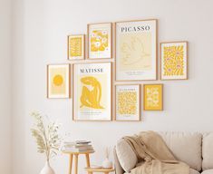 a living room filled with furniture and framed pictures on the wall above a white couch