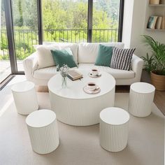 a living room filled with white furniture and lots of windows