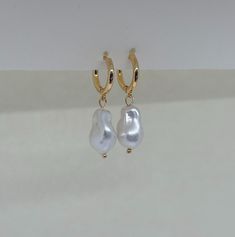 Beautiful earrings with freshwater pearls. Since the pearl is a natural freshwater pearl, no two pearls are exactly the same shape. The gold hoop earrings add to her elegant look and the earrings go perfectly with an elegant outfit, but can also be worn every day. What makes our jewelry special? 🌊 The high-quality, gold-plated stainless steel makes the jewelry waterproof ✨ No discoloration, no green edges 🌿 Allergy-friendly 🫀 each piece of jewelry is selected with love and lovingly packaged ? Delicate Baroque Pearl Earrings With Pearl Charm, Classic White Huggie Pearl Earrings, Delicate White Gold Plated Pearl Earrings, Delicate White Gold-plated Pearl Earrings, White Baroque Pearl Earrings As A Gift, Minimalist White Gold Plated Pearl Earrings, Gold Minimalist Drop Pearl Earrings, White Gold Plated Minimalist Pearl Earrings, Minimalist White Gold-plated Pearl Earrings