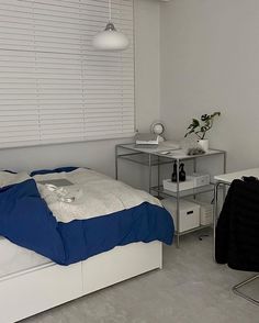 a bedroom with white walls and blue sheets