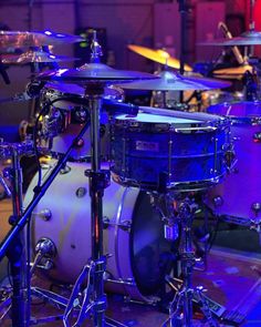 a drum set up on stage with blue lighting