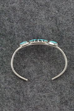 This finely crafted turquoise and sterling silver bracelet was made by Zuni silversmith Carla Laconsello. The back is signed.Size: 5 1/8" (will fit up to a 6 1/8" wrist)Gap: 1"Length: 1 1/4"Free shipping on all orders! We ship with USPS and always include tracking. All orders ship within a day of payment.Returns are accepted up to 30 days after you receive your order. Just send us a message. Our shop offers cash back or store credit. The item must be returned in new condition. Elegant Turquoise Bracelet With Inlay, Turquoise Bangle For Formal Occasions, Elegant Turquoise Inlay Bracelet, Formal Turquoise Bangle Jewelry, Turquoise Oyster Bracelet In Sterling Silver, Turquoise Sterling Silver Oyster Bracelet, Sterling Silver Turquoise Oyster Bracelet, Turquoise Sterling Silver Bracelet, Adjustable Turquoise Bracelet With Inlay