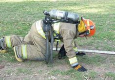 a firefighter is laying on the ground with his head down and tools in hand