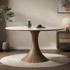 a white table in a living room next to a vase and potted plant on the floor