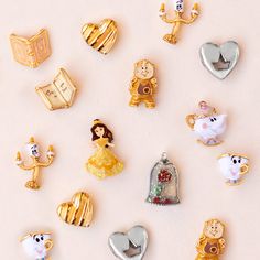 many disney princess pins are arranged on a white surface, including beauty and the beast