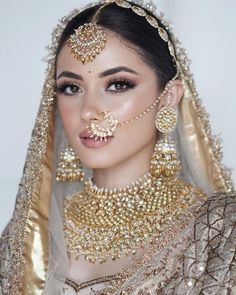 a woman in a bridal outfit with jewelry on her face