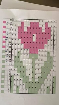 a cross stitch pattern on top of a white piece of paper with pink and green squares