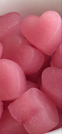 some pink hearts are in a white bowl