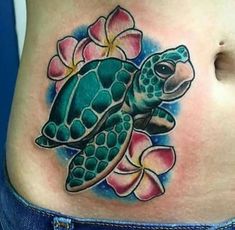 a woman's stomach with a turtle and flowers tattoo on the side of her belly