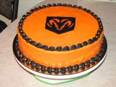 a cake with an orange and black frosting design on the top is sitting on a table