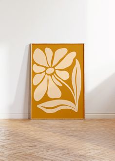 an orange and white flower is on the floor in front of a wall with wood floors