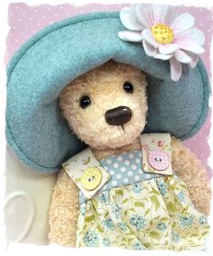 a teddy bear wearing a blue hat and dress