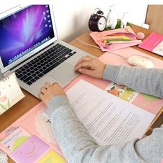 a person sitting at a desk with a laptop and papers in front of them,