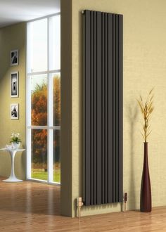 a modern radiator in a living room with wood flooring and large windows