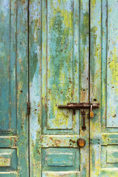 two green doors with rusted metal handles