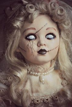 a creepy doll with long blonde hair and blue eyes