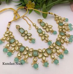 This Kundan choker set is crafted from quality materials with a stylish floral design in mint green stones and gold Plating. The perfect statement piece for any special occasion, its timeless aesthetic and intricate details make it ideal for weddings, parties, and more. This set includes a chic choker necklace and matching maang tikka. Green Bollywood Style Sets For Gifts, Green Meenakari Party Sets, Gold Kundan Choker, Kundan Choker Necklace, Kundan Choker Set, Kundan Choker, Maang Tikka, Green Stones, Timeless Aesthetic