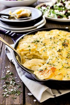 a casserole dish filled with mashed potatoes and garnished with herbs