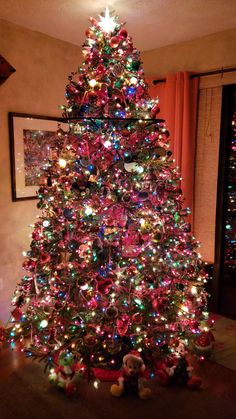 a brightly lit christmas tree in a living room