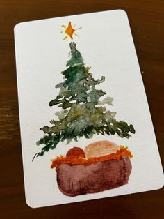 a watercolor painting of a christmas tree with a baby in a mangerow