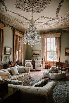 a living room filled with lots of furniture and a chandelier hanging from the ceiling