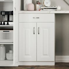 a white cabinet with two doors and some items on the top shelf next to it