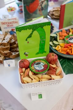 there are many different foods on the table and one has a green book in it