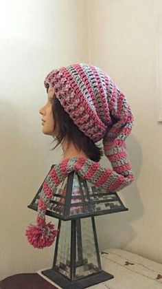 a mannequin head wearing a pink and white knitted hat