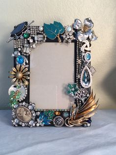 an ornate photo frame is adorned with jewels and other jeweled items, including a bird