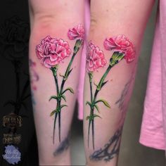 two tattoos with pink flowers on their legs and one has green stems in the middle