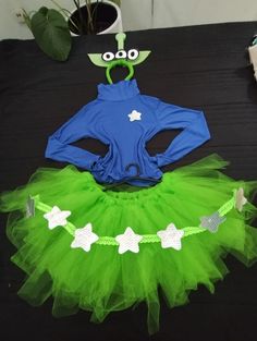 a green and blue outfit with stars on it sitting on top of a black table