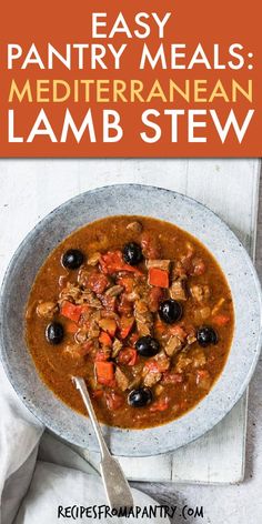 a bowl filled with meat and vegetables on top of a white table next to a spoon