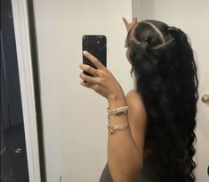 a woman taking a selfie in front of a mirror with her hair pulled back