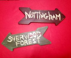 two wooden signs that say nottingham and sherwood forest on red background