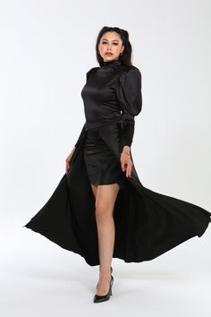 Crafted from a premium blend of 60% polyester, 37% cotton, and 3% spandex, the Genesis dress embodies luxury with its Dolce Satin fabric, offering a smooth, slightly stretchy feel that drapes beautifully and moves with grace. Designed to flatter, its silhouette hugs curves elegantly, enhanced by dramatic puff sleeves and a flowing cape that adds sophistication and movement. Versatile and effortlessly chic, the Genesis dress transitions seamlessly from day to night, whether styled with heels and Fitted Pre-draped Asymmetrical Dress With Ruched Detail, Fitted Long Sleeve Pre-draped Evening Dress, Fitted Pre-draped Satin Evening Dress, Fitted Pre-draped Satin Dress For Gala, Fitted Knee-length Midi Dress With Draped Sleeves, Silk Stretch Maxi Dress For Night Out, Satin Dress With Asymmetrical Hem For Date Night, Fitted Draped Maxi Dress, Fitted Pre-draped Long Sleeve Maxi Dress