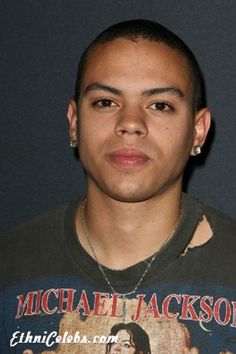 a young man wearing a michael jackson t - shirt and silver earrings is looking at the camera