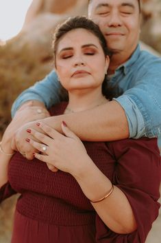 a man and woman hugging each other in the desert