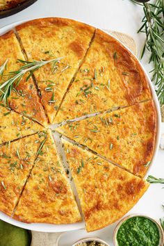 a cheese pizza with slices cut out and surrounded by other toppings on a white table