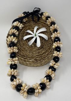 "MADE TO ORDER ONLY.  THIS LISTING IS FOR THE NECKLACE ONLY, FLOWER IS NOT INCLUDED. NOTE- THE DISPLAYED PICTURE ITS A 28\" LONG NECKLACE. WE CAN MAKE THE ROSETTES WITH BROWN, BLACK OR BEIGE KUKUI NUTS. Made with Genuine Kukui nuts and cowrie shells ring or rosettes . Suitable for kids and adult.  Great for a necklace that will last for years ...a wedding, gift or luau.  Measurements= choose your length on the drop box. These nuts don't bleed onto clothing.  These necklace or Lei are very popula Artisan Black Jewelry For The Beach, Artisan Black Necklace For Beach, Handmade Flowers Adjustable Beach Jewelry, Black Artisan Necklace For Beach, Black Artisan Necklaces For Beach, Traditional Black Necklaces For Beach, Traditional Black Necklaces For The Beach, Cowry Shell, Kukui Nut