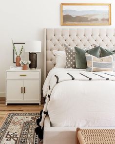 a white bed sitting next to a wooden dresser