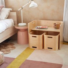 a bedroom with a bed, desk and storage bins on the floor in front of it