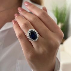 a woman's hand with a ring on it and a blue stone in the middle