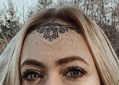 a woman with her face painted like a snowflake is looking at the camera